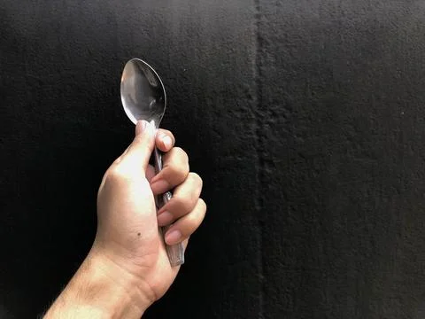 Human hand holding a spoon Stock Photos