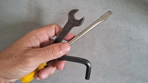 Human hand holding various old rusty metal construction repair tools Stock Photos
