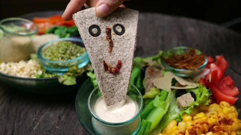 A human hand holds a triangular piece of bread made from gluten-free wheat with Stock Footage 221224352