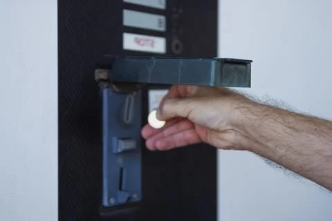 Human hand inserting a coin into a vending machine slot for payment, illust.. Stock Photos