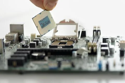The human hand is installing the processor on the motherboard. Stock Photos
