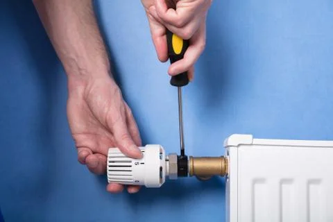 Human Hand Installing Radiator With Screwdriver Stock Photos