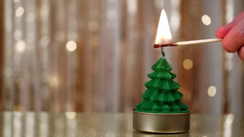 Human hand lighting christmas tree shaped candle with match. closeup. Stock Footage 319521387