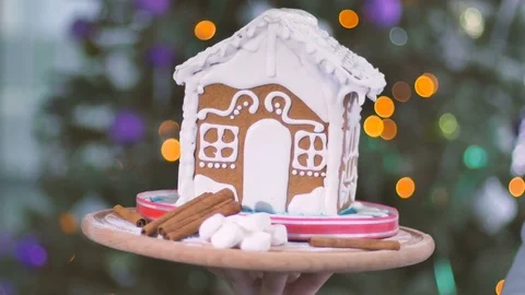 Human hand is moving the tray with gingerbread house and decoration elements Stock Footage 75541310