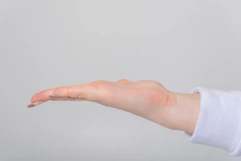 Human hand with open empty palm presented horizontally on a neutral grey ba.. Stock Photos