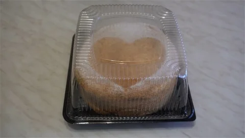 Human hand open transparent cover honey cake with a heart Stock Footage 82733960