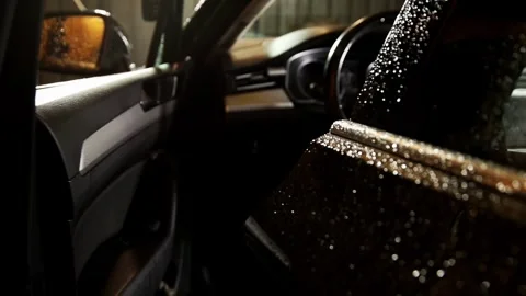 Human hand opens and closes car door. Dark vehicle exterior glistens with water Vídeo Stock 325296357