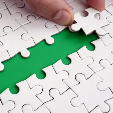 The human hand paves the way to the surface of the jigsaw puzzle, forming a g 写真素材