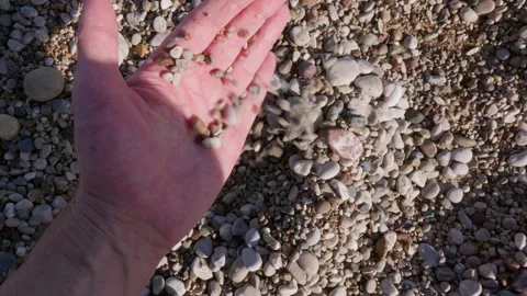 Human hand picking pebbles on beach, sensory moment Stock Footage 327830739