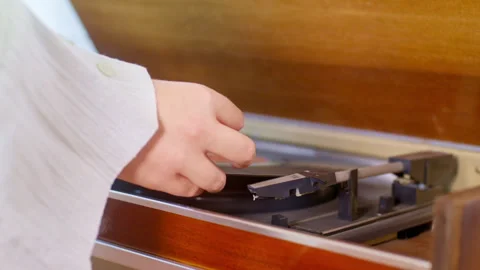 Human hand placing a vinyl record onto a retro turntable. Stock Footage 306876399