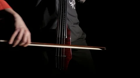 Human hand playing electric cello, close-up of strings, bow and fingerboard Stock Footage 107871832