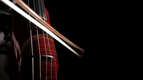 Human hand playing electric cello, close-up of strings, bow and fingerboard Stock-Footage 107871888