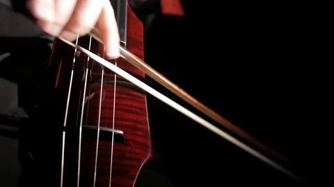 Human hand playing electric cello, close-up of strings, bow and fingerboard Vídeo Stock 107871908