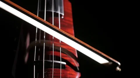 Human hand playing electric cello, close-up of strings, bow and fingerboard Stock-Footage 107871927
