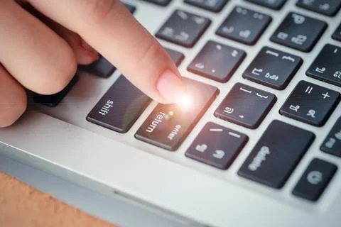 Human hand press enter or confirm button on computer keyboard Stock Photos
