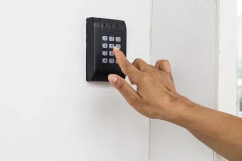 Human hand presses on the button, entering security system code. Combination Stock Photos