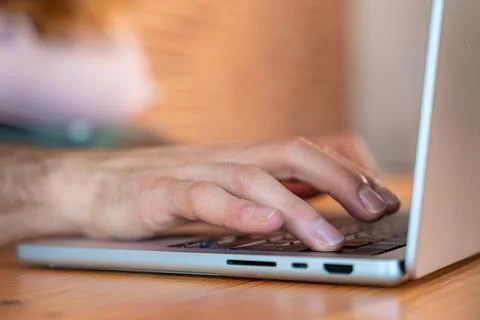 Human hand presses power button on laptop keyboard Stock Photos