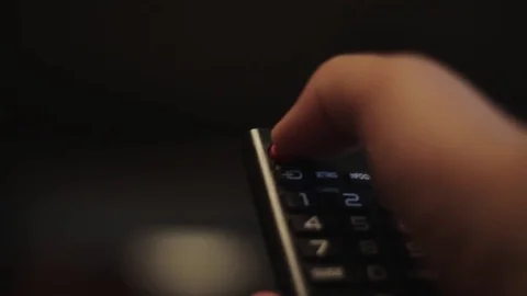 Human hand is pressing button on black TV remote control Stock Footage 69874191