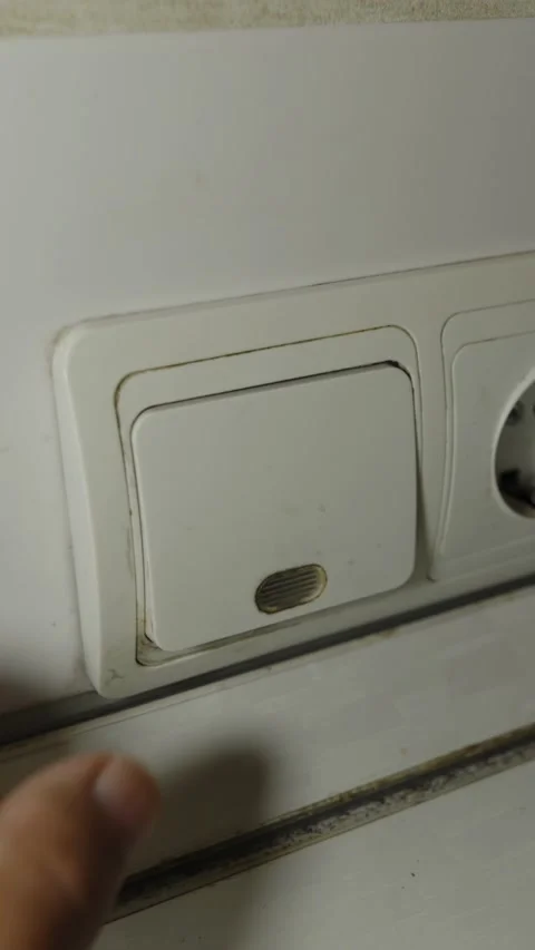 A human hand pressing a white light switch with indicator Stock Footage 336799154