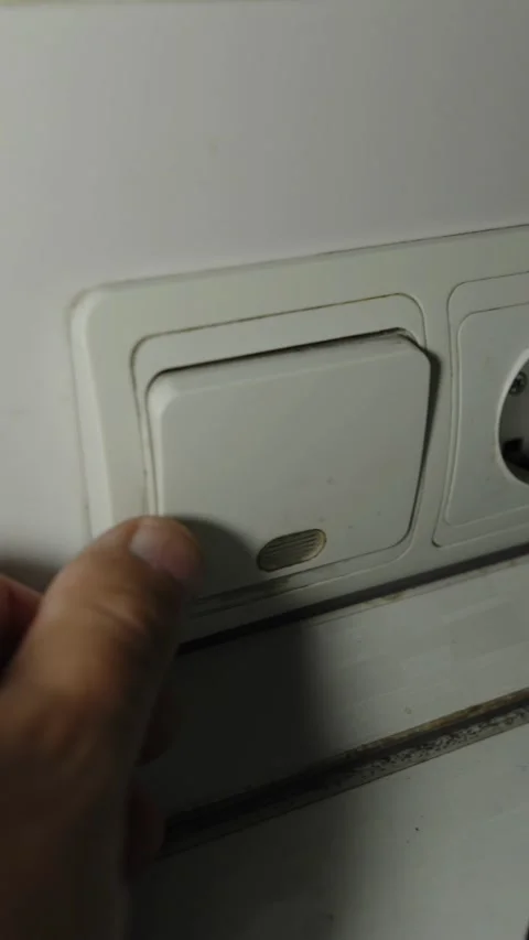 A human hand pressing a white light switch with indicator Stock Footage 336799162