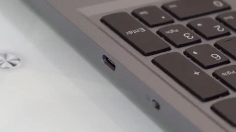 A human hand pulls out or inserts a USB Type-C cable into a laptop Stock Footage 327896406
