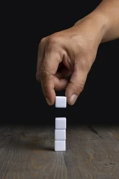A human hand put a stack of small cubes Stockfoto's