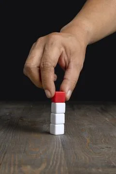 A human hand put a stack of small cubes Stock Photos