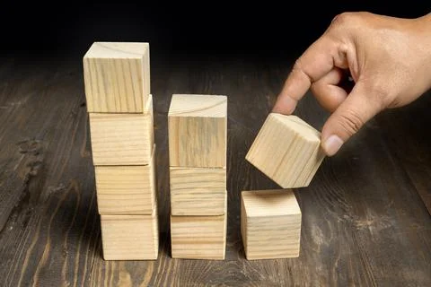 A human hand put a stack of wooden cubes Stock Photos