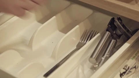 Human hand puts clean spoons and forks in the tray. Video stock 293034475