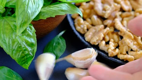 Human hand puts several cloves of garlic on the table. Ingredients for a sauc Stock Footage 94078534