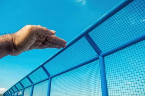 A human hand reaches outward, seemingly interacting with a long, vibrant bl.. Foto stock