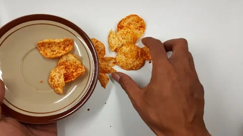 Human hand reaching for and taking spicy chips, snack time motion. Video stock 330293103