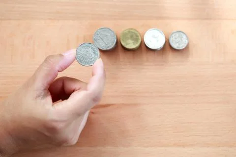 Human hand saving money on stacking coins Stock Photos