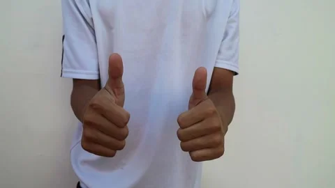 A human hand showing a thumbs up gesture against a plain white background. Stock Footage 344563570