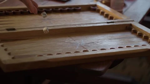 Human hand slowly rolls the dice before playing backgammon on the board Stock Footage 161190438