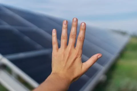 Human hand on solar panel blurred background, photovoltaic, alternative Stock Photos
