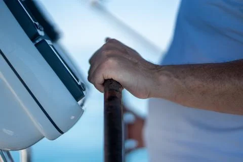 Human hand steering a boat helm feeling control and navigation Stock Photos