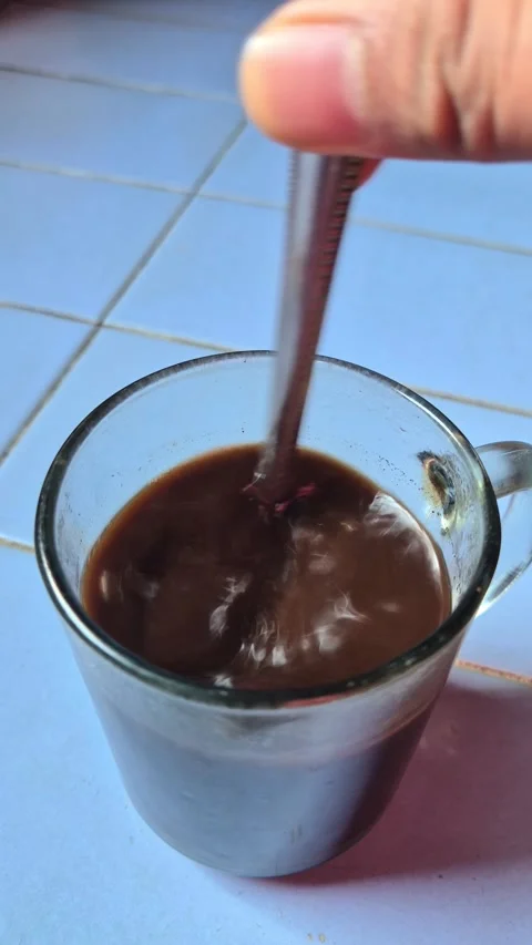 A human hand stirring hot black coffee Stock Footage 338253469