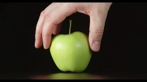 Human hand takes away a half of green apple Stock Footage 62425617
