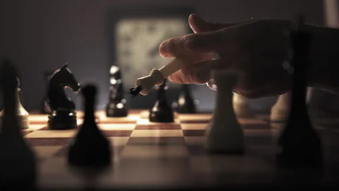 Human hand takes a queen from chessboard, deftly juggles it and places it back Stock Footage 312814428