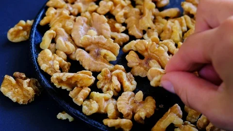 Human hand takes a walnut cernel from  the hot pan Stock Footage 94078536