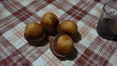 Human hand taking a muffin from a checkered tablecloth Video stock 320407482