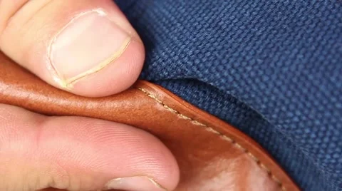 Human hand testing brown leather material of bag, bottom Видео 50970610
