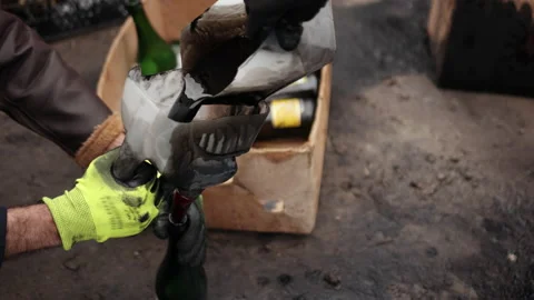 Human hand through a funnel pours oil into a bottle for making Molotov cocktail 動画素材 171241947