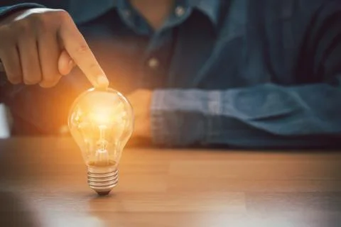 Human hand touch light bulb. Business, Innovation and creative design concept Stock Photos