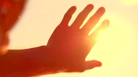 Human hand touching the sunlight by hand over beautiful sky background. Stock Footage 59085037