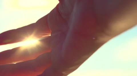 Human hand touching the sunlight by hand over beautiful sky background. Stock Footage 59090365