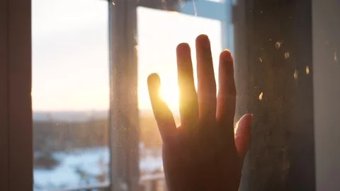 Human hand touching window glass at sunset shines Video stock 336267900