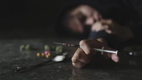 Human hand trying to reach, on concrete floor. Drugs addiction and withdraw.. Stock Footage 336936019