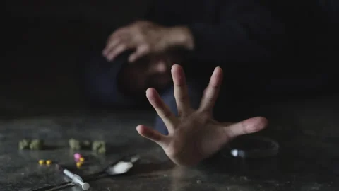Human hand trying to reach, on concrete floor. Drugs addiction and withdraw.. Stock Footage 336936082